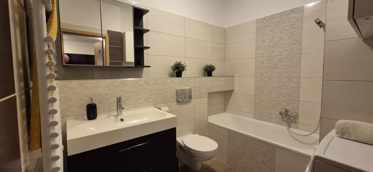 Fürdőszoba mosdóval, fali WC-vel és káddal